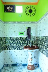 a bathroom with a sink and a clock on the wall at HOLIDAY INN in Konārka