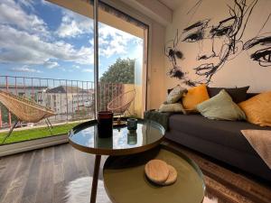 sala de estar con sofá y mesa de cristal en Angèle - Relaxez-vous ! en La Roche-sur-Yon