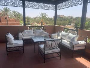 a patio with white furniture and a table and chairs at Villa Mezouza in Marrakesh