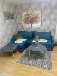 a living room with a blue couch and a table at NEU! Ferienwohnung Milo Pfälzer Wald in Rodalben