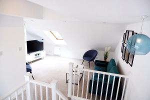ein Wohnzimmer mit einem Sofa und einem TV in der Unterkunft Comfortable cozy 4bed house nearby the hospital! in Cambridge