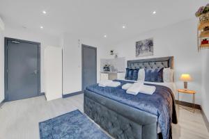 a bedroom with a large bed with blue sheets and pillows at Lovely 1-Bed Studio in Feltham in Feltham