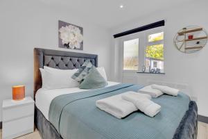 a bedroom with a bed with two towels on it at Serviced Ensuite Studio in Feltham London Heathrow in Feltham