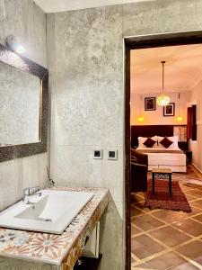 uma casa de banho com um lavatório e um quarto com uma cama em Riad Al Wafaa em Marrakech