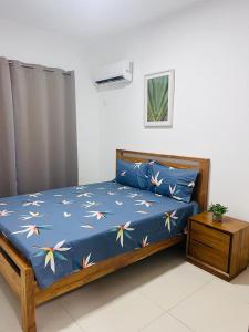 - un lit avec une couette bleue et des fleurs dans l'établissement Azure 4 Bedrooms Haven Retreat: Where Tranquility Meets Turquoise Waters, Flic en Flac Mauritius, à Flic-en-Flac