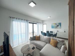 a living room with a couch and a table at Azure 4 Bedrooms Haven Retreat: Where Tranquility Meets Turquoise Waters, Flic en Flac Mauritius in Flic-en-Flac
