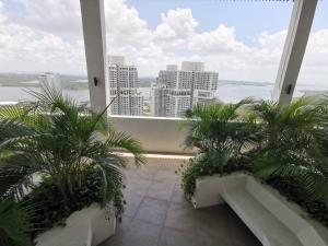 balcón con palmeras y vistas a la ciudad en C1108 Almas Suites Muji Studio100mbpsNetflix STAY, en Nusajaya