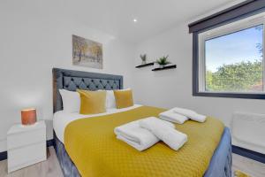 a bedroom with a yellow bed with towels on it at Inviting 1-Bed House in Feltham in Feltham