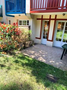 a house with a patio and a table in front of it at cottage « maison du golf » à Moliets in Moliets-et-Maa