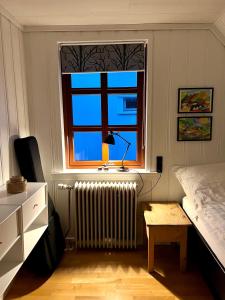 um quarto com uma cama, uma janela e um radiador em Cozy traditional home, Syðrugøta em Syðrugøta