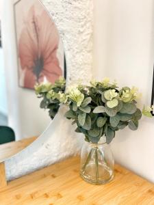 a vase with flowers on a table in front of a mirror at Tennessee Studio Malaga in Málaga