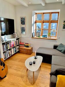 uma sala de estar com um sofá e uma mesa em Cozy traditional home, Syðrugøta em Syðrugøta