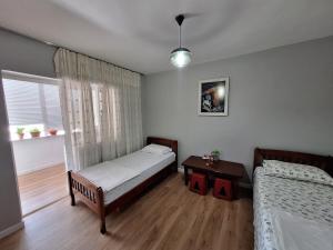 a bedroom with two beds and a table in it at Ergi's Host Apartment in Krujë