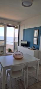a dining room with a white table and chairs at LAMAR SUITES Seafront Apartments in Misano Adriatico +35 photos