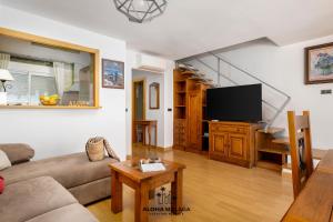 a living room with a couch and a flat screen tv at Lucila Beachfront Pedregalejo By AlohaMálaga in Málaga