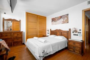 1 dormitorio con cama, tocador y espejo en Lucila Beachfront Pedregalejo By AlohaMálaga, en Málaga