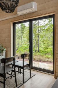 Habitación con mesa, sillas y ventana grande. en Mysig liten stuga perfekt för par eller liten familj en Sälen