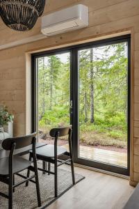 a room with a table and chairs and a large window at Mysig liten stuga perfekt för par eller liten familj in Sälen