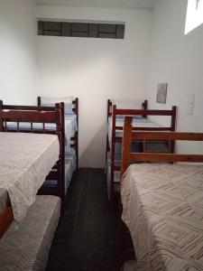 a room with three bunk beds in a room at Pousada Santana in Cachoeira Paulista