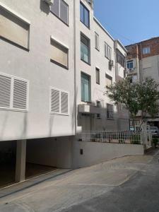 un edificio blanco con balcón en una calle en Nazari Apartment 1, en Tirana