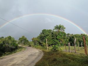 un arc-en-ciel sur un chemin de terre dans l'établissement Maison de plage à Santo Antonio, à Santa Cruz Cabrália