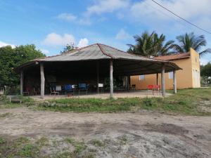 un pavillon avec des chaises et des tables et un bâtiment dans l'établissement Maison de plage à Santo Antonio, à Santa Cruz Cabrália