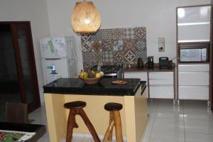 a kitchen with a counter with a bowl of fruit on it at Maison de plage à Santo Antonio in Santa Cruz Cabrália