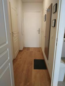a hallway with a white door and wooden floors at Studio au cœur de Valberg à proximité des pistes in Valberg