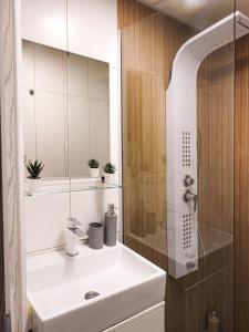 un bagno con un lavandino bianco e uno specchio di Vukov spomenik a Belgrado