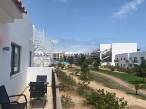 a balcony of a building with chairs and a street at Salisland365 Private Apartment - Self Catering Dunas Beach Resort in Santa Maria