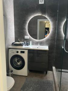 ein Badezimmer mit einer Waschmaschine und einem Waschbecken in der Unterkunft Стильна чудова квартира в місті Тернопіль in Ternopil