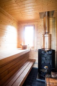 a sauna with a stove and a window in it at Majutus saunaga majakeses in Öötla