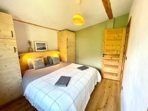 um quarto com uma grande cama branca e pisos em madeira em Chalet familial Saint-Gervais em Saint-Gervais-les-Bains