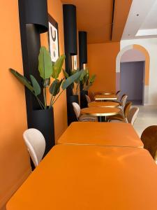 an office with orange tables and chairs and plants at Ostello e Camere Private Prima Luce Foresteria in Giulianova