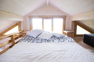 a bed in a room with two windows at Majutus saunaga majakeses in Öötla