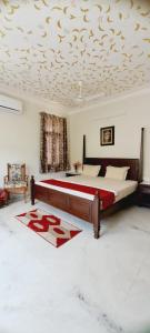 um quarto com uma cama e um tecto com um cobertor vermelho em Colonels Homestay em Udaipur