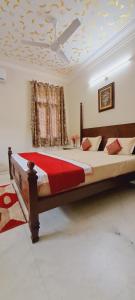 um quarto com uma cama grande e um cobertor vermelho em Colonels Homestay em Udaipur