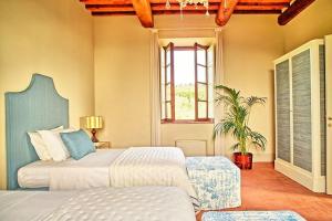 ein Schlafzimmer mit zwei Betten und einem Fenster in der Unterkunft Casa Lionardo by PosarelliVillas in Vinci + 27 Fotos