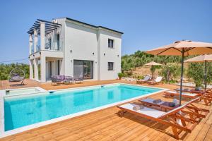 a villa with a swimming pool and a house at Olive grove villa in Plátonas