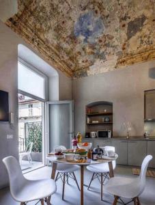 een keuken met een tafel en stoelen en een plafond bij Le Tre Ca', Ca' Cecilia, Ca' Nina, Ca' Vittoria in Asti