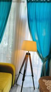 a lamp in front of a window with blue curtains at Apartament - Lisa in Budva