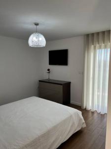 a bedroom with a white bed and a television at Quinta do Carregal in Mangualde