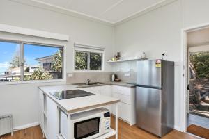 a kitchen with a stainless steel refrigerator and white cabinets at Blue Waters in Point Lookout +5 photos
