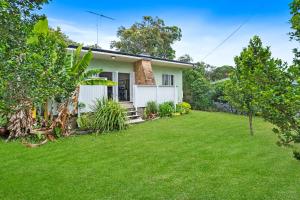 a house with a lawn in front of it at Frogmouth - 87 Mooloomba Road in Point Lookout
