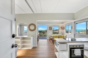 a kitchen and dining room with white cabinets and a table at Blue Waters in Point Lookout
