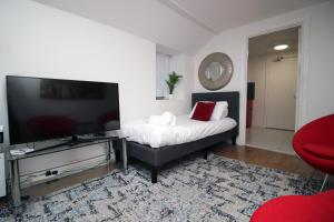 a bedroom with a bed and a flat screen tv at Spacious 5 Bedroom Apartment In Swansea in Swansea