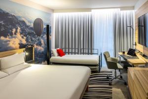 a hotel room with two beds and a desk at Novotel Leeds Centre in Leeds