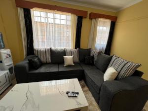 Naivasha 1BR Apartment في نيفاشا: غرفة معيشة مع أريكة وطاولة قهوة