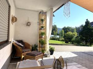 un patio con 2 sillas y una mesa en un porche en Morgensonne, en Gutach im Breisgau