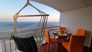 a balcony with a table and chairs and the ocean at Sesimbra Sun&Sea - Beachfront Apartment! in Sesimbra